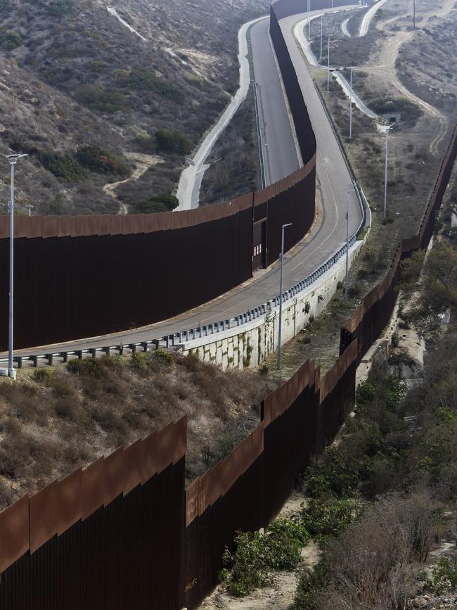 A National Guard officer monitors the border wall between Mexico and the US. Picture: Gerry Images.