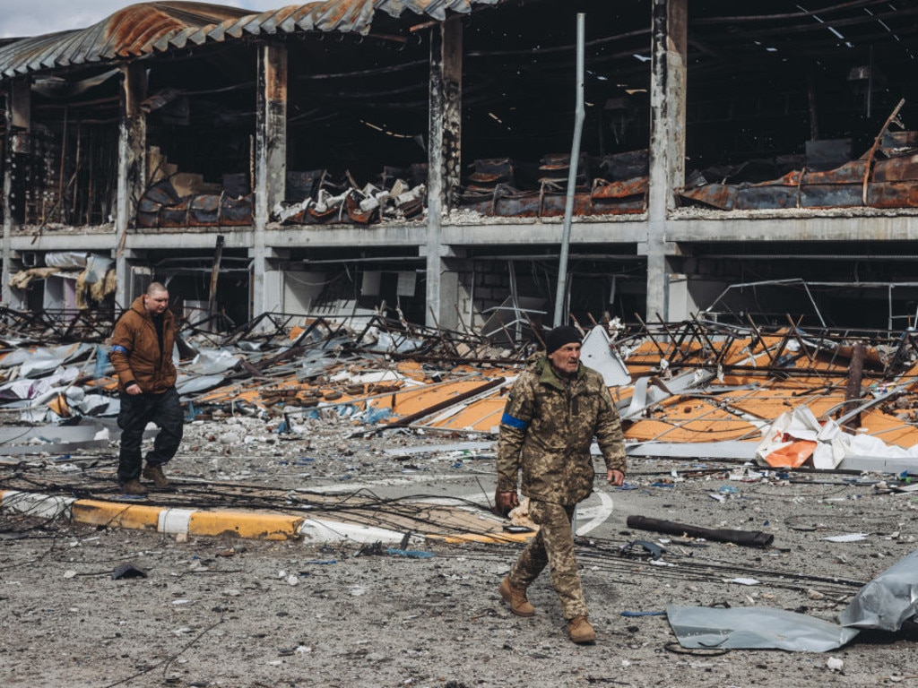 Ukrainian soldiers walk through the destroyed village of Bucha, as Russian attacks continued on April 4, 2022.