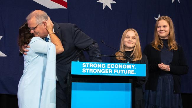 Scott Morrison hugs wife Jenny on election night as daughters Abbey and Lily look on. Picture: Jason Edwards