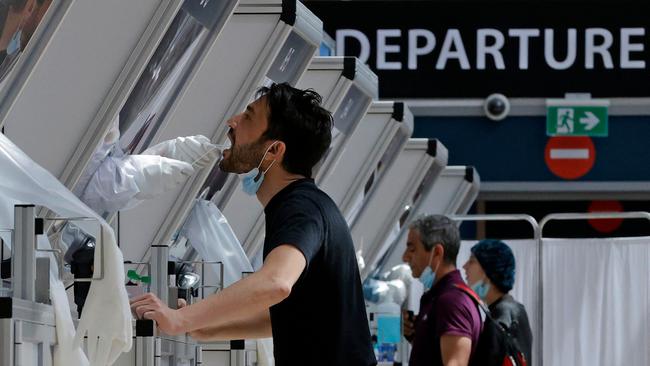 A medic collects a swab sample from a traveller at a rapid COVID-19 testing booth in Israel's Ben Gurion Airport, near Tel Aviv, this week. Picture: AFP