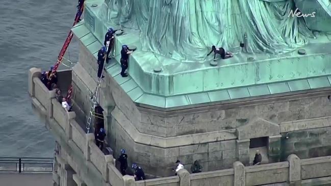 A woman climbs onto the Statue of Liberty | news.com.au — Australia’s ...