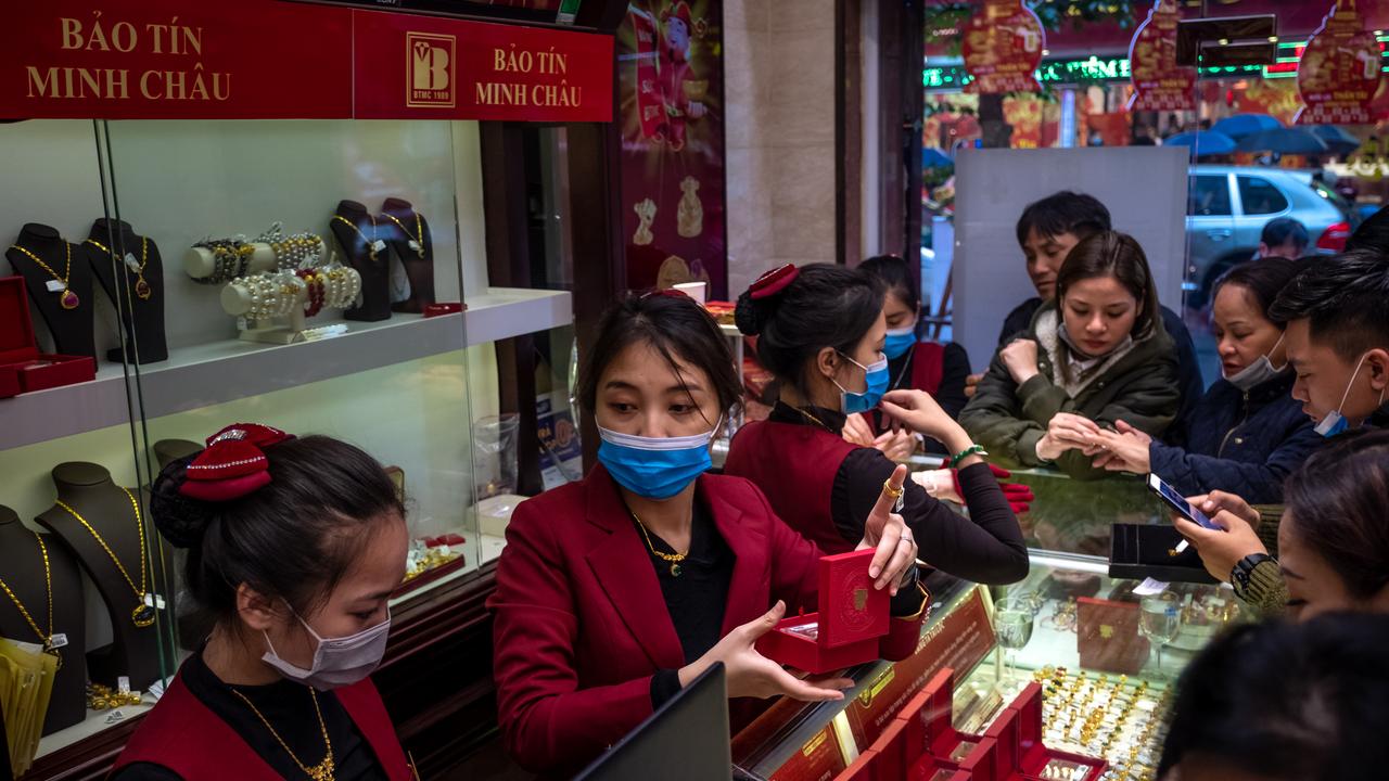 Gold shop employees wear face masks while serving customers in Hanoi, Vietnam. Picture: Supplied