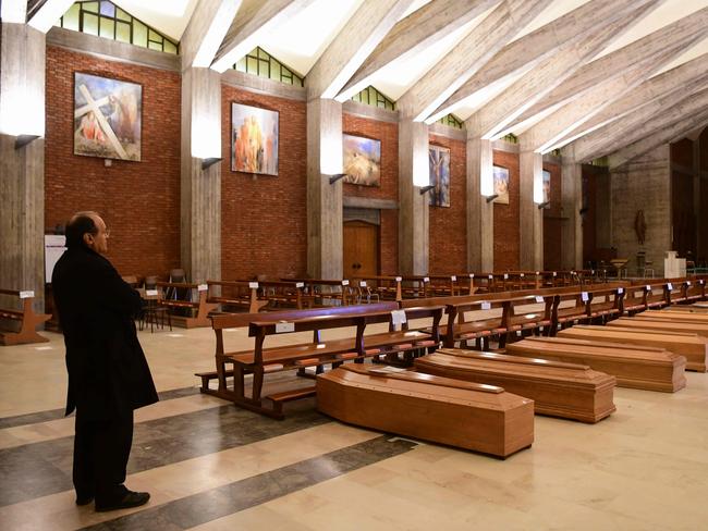 Parish priest of Seriate, Don Mario stands by coffins stored in the church of San Giuseppe in Seriate, Italy. Picture: AFP