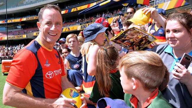 Crows coach Don Pyke signs autographs for fans at the end of training at Adelaide Oval on Wednesday. Picture: Mark Brake/Getty Images