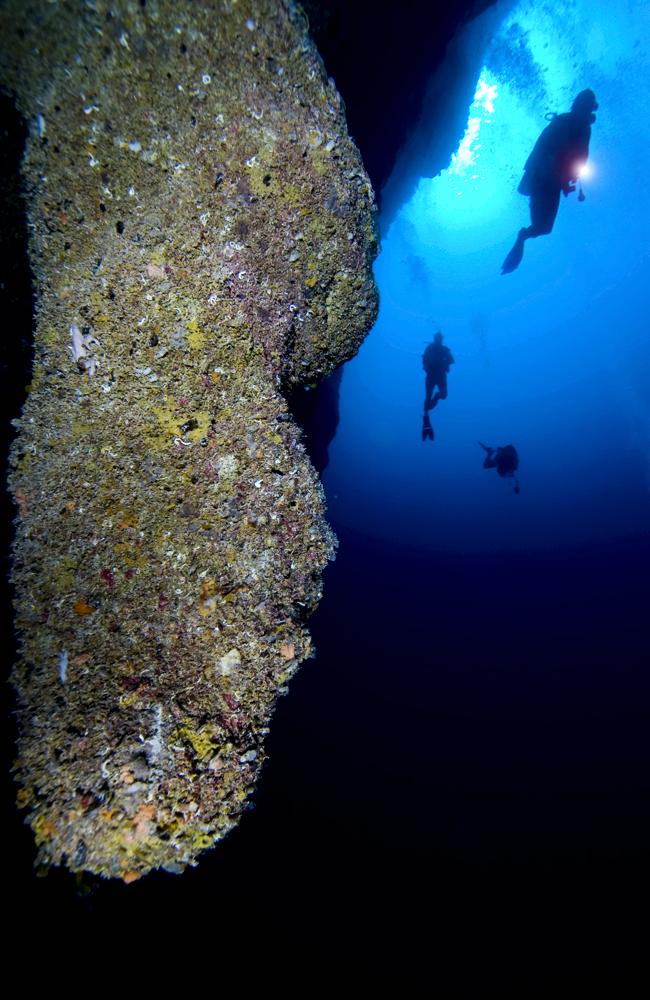 Divers descend to stalactites in Blue Hole. Tim Rock/Lonely Planet