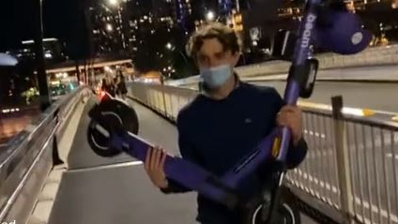 A man throws a scooter into the Brisbane River.