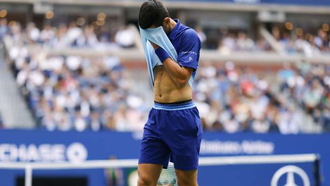 NEW YORK, NEW YORK - SEPTEMBER 12: Novak Djokovic of Serbia dries his face as he plays against Daniil Medvedev of Russia during their Men's Singles final match on Day Fourteen of the 2021 US Open at the USTA Billie Jean King National Tennis Center on September 12, 2021 in the Flushing neighborhood of the Queens borough of New York City.   Al Bello/Getty Images/AFP == FOR NEWSPAPERS, INTERNET, TELCOS & TELEVISION USE ONLY ==