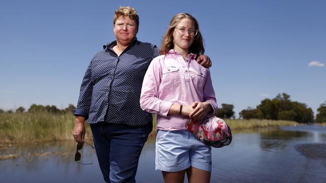 Farmer Melissa Brown with daughter Halle at their flooded farm near Forbes on Thursday. Picture: Jonathan Ng