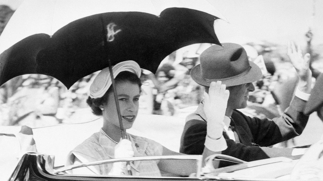 (FILE PICS) (Original Caption) 3/20/1954-Townsville, Australia- The top was back so the crowds could see Queen Elizabeth II and the Duke of Edinburgh as they drove through Townsville, Queensland, recetly, so Liz hoisted a sunshade with one hand and waved to the crowds with the other. Well, they say the sun never sets on the British empire...