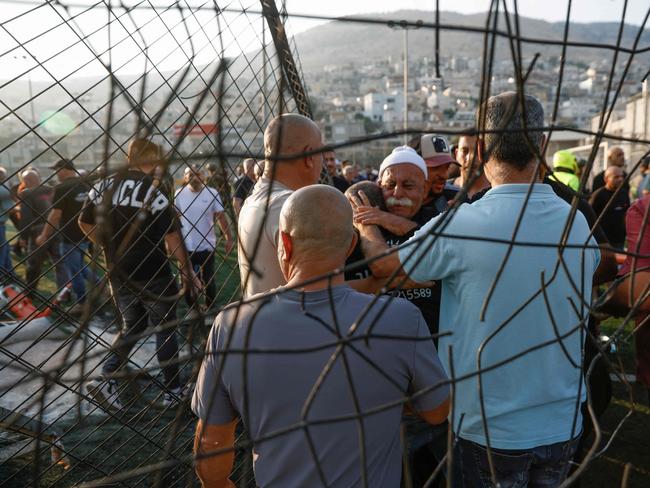 Residents comfort each other as they gather at a site where children were killed in Majdal Shams. Picture: AFP