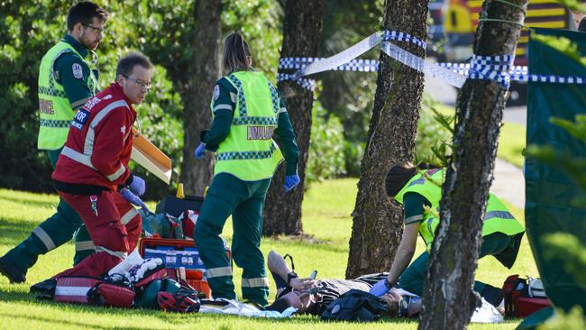 Paramedics help the two cyclists who were run down by the out-of-control van on Military Rd, West Beach. Picture: AAP / Brenton Edwards