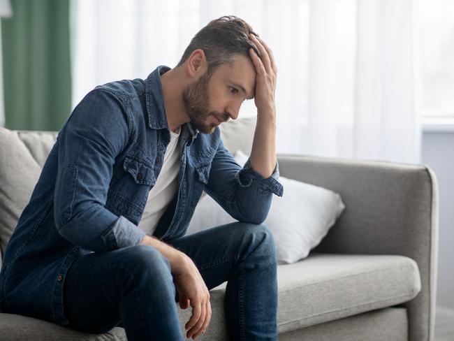 MENTAL HEALTH -  Frustrated middle-aged man sitting on sofa in living room, touching his forehead, having financial troubles during quarantine or suffering from loneliness, copy space, home interior Picture: Istock