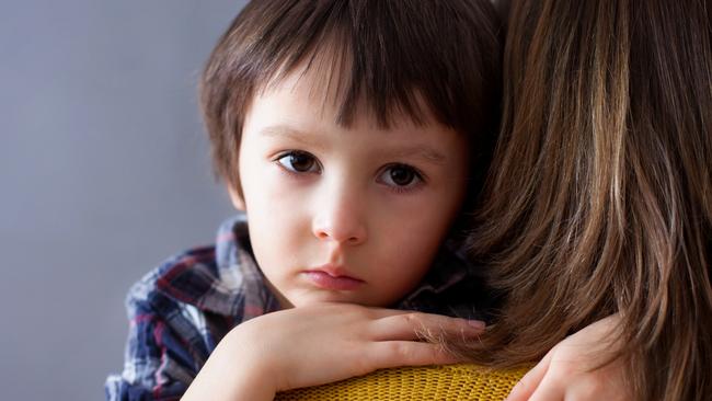 Sad little child, boy, hugging his mother at home, isolated image, copy space. Family concept