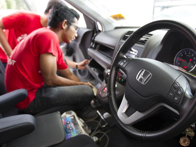 In this Sunday, Nov. 20, 2016, photo, a Honda technician works on an airbag during a free airbag replacement event in Kuala Lumpur, Malaysia. A Malaysian man whose wife's death is one of at least 16 blamed on air bag defects has sued Japanese automaker Honda and the Takata Corp. in a U.S. court, saying he wants the companies to disclose more about the dangers. (AP Photo/Lim Huey Teng)