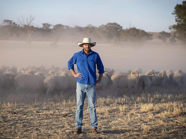 14/12/19: Marino sheep farmer, Nick Kershaw with his dogs Bow(red) and Wally on his property near Young, NSW. John Feder/The Australian.