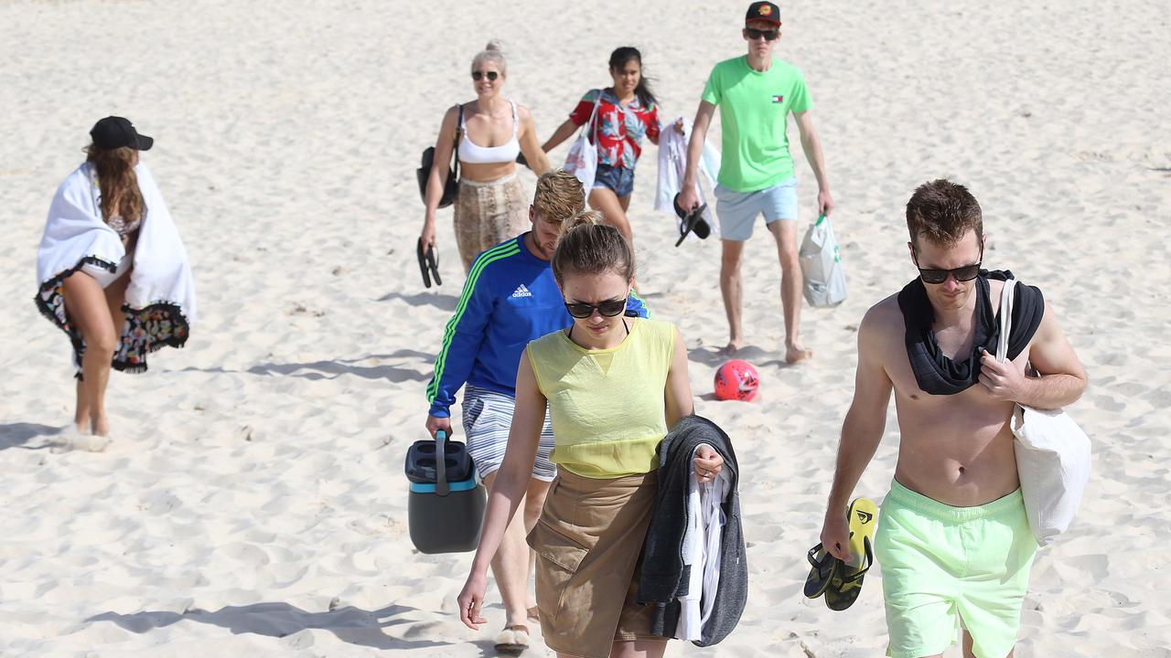 Beachgoers pack up and head home after it was announced the beach would be closed. Picture: Matrix Pictures