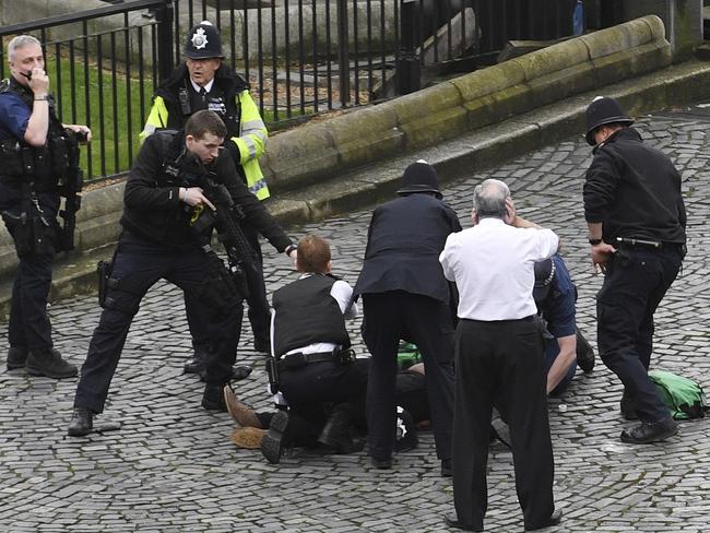 A policeman points a gun at the suspect after he is taken down by officers. Picture: AP