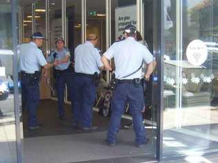 Police officers seize two swords from a man in the Toowoomba CBD.