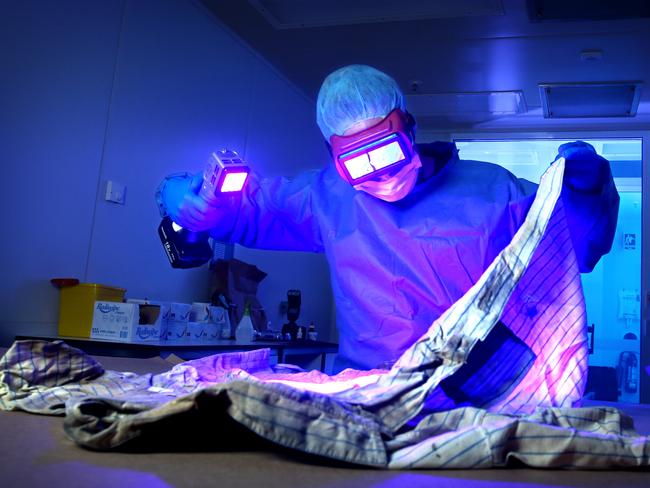 Sgt Kim McNamara conducts a UV light examination of a murder exhibit. Picture: Steve Pohlner