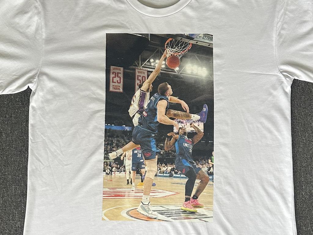 The Sydney Kings have designed a T-shirt with a picture of star Xavier Cooks dunking on Melbourne United big man Isaac Humphries.