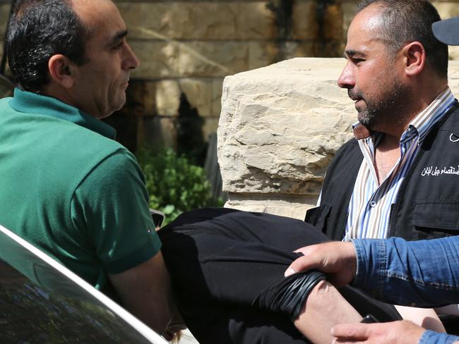 A policeman holds Tara Brown’s head down outside the court. Picture: AP/Hussein Malla.