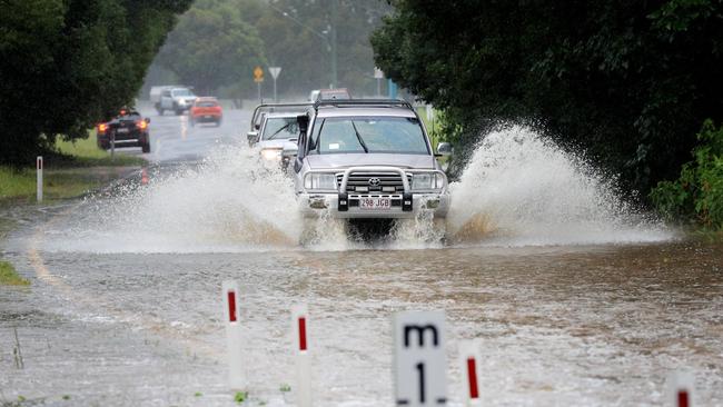 Drivers ignore rising flood water across Tallebudgera Connection Road, Tallebudgera , at the back of Currumbin Creek after torrential rain over night caused the creek to break its banks. NCA NewsWire / Scott Powick