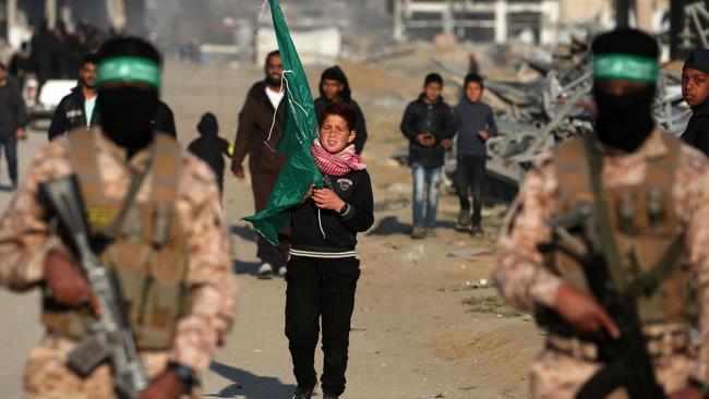 Palestinian Hamas fighters stand guard near the family home of slain Hamas leader Yahya Sinwar, where the militant group prepares to hand over Israeli and Thai hostages to a Red Cross team in Khan Yunis on January 30. Picture: AFP