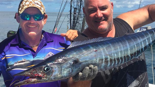 Steve Castle (left) with an extremely-rare NT wahoo is helped by Darwin Bluewater Charters crew member, Gary Lee.