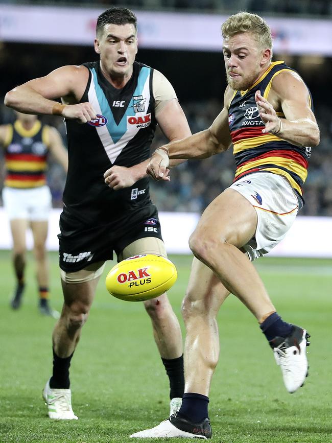 Tom Rockliff puts pressure on Crow Hugh Greenwood in Showdown 46. Picture: SARAH REED.