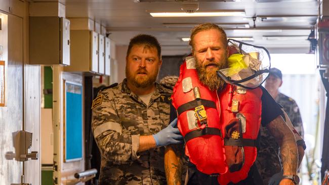 Chief Petty Officer Peter Gough leads Mr Mockus to the ship’s hospital on-board HMAS Choules. Picture: Supplied / AMSA