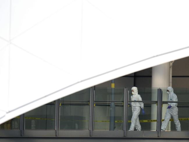 Forensic officers walk along a raised walkway by Manchester Arena. Picture: AFP / Oli Scarff