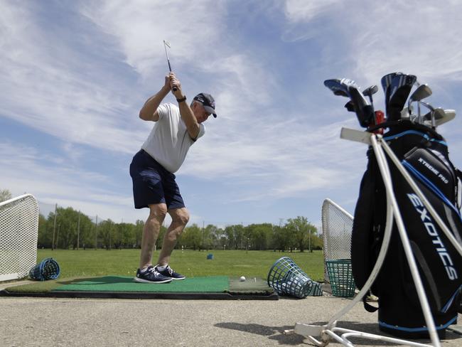 Ken Gilenwater hits on the driving range at the Orchard Golf Center, Monday, May 4, 2020, in Greenwood, Ind. Indiana started relaxing coronavirus restrictions, with the goal of allowing nearly all activities to resume on July 4. A new executive order that took effect allowing more manufacturers, retailers and shopping malls to reopen in most of the state while directing residents to maintain social distancing of at least six feet and to wear face coverings in public. (AP Photo/Darron Cummings)