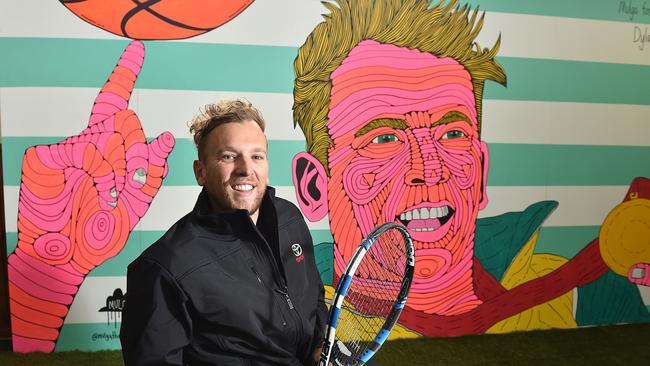 Paralympian Dylan Alcott with a mural of him painted by Mulga at Kingsville tennis Club. Picture: Ellen Smith