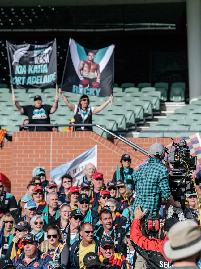 Crows and Port Adelaide fans cheering and sitting together on the southern side of Adelaide Oval as extras in the film 