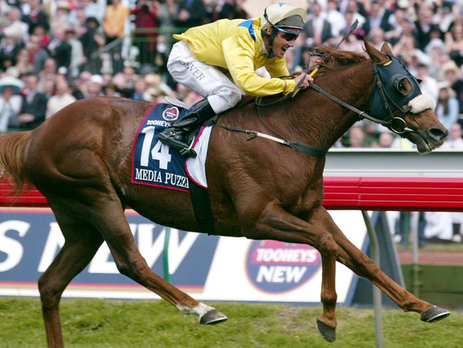 (FILES) A file photo taken on November 5, 2002, shows Australian jockey Damien Oliver winning the in the four million dollar (1.8 million USD) Melbourne Cup on Media Puzzle, in Melbourne.  Oliver was banned from racing for 10 months on November 20, 2012 after blaming his marriage breakdown for a decision to put money on a rival horse that won a race in which he was riding.  The Australian two-time Melbourne Cup winner was suspended for eight months over the betting scandal and was slapped with another two month ban for using a mobile phone in the jockeys' room prior to the race, which is prohibited.  AFP PHOTO/William WEST/FILES