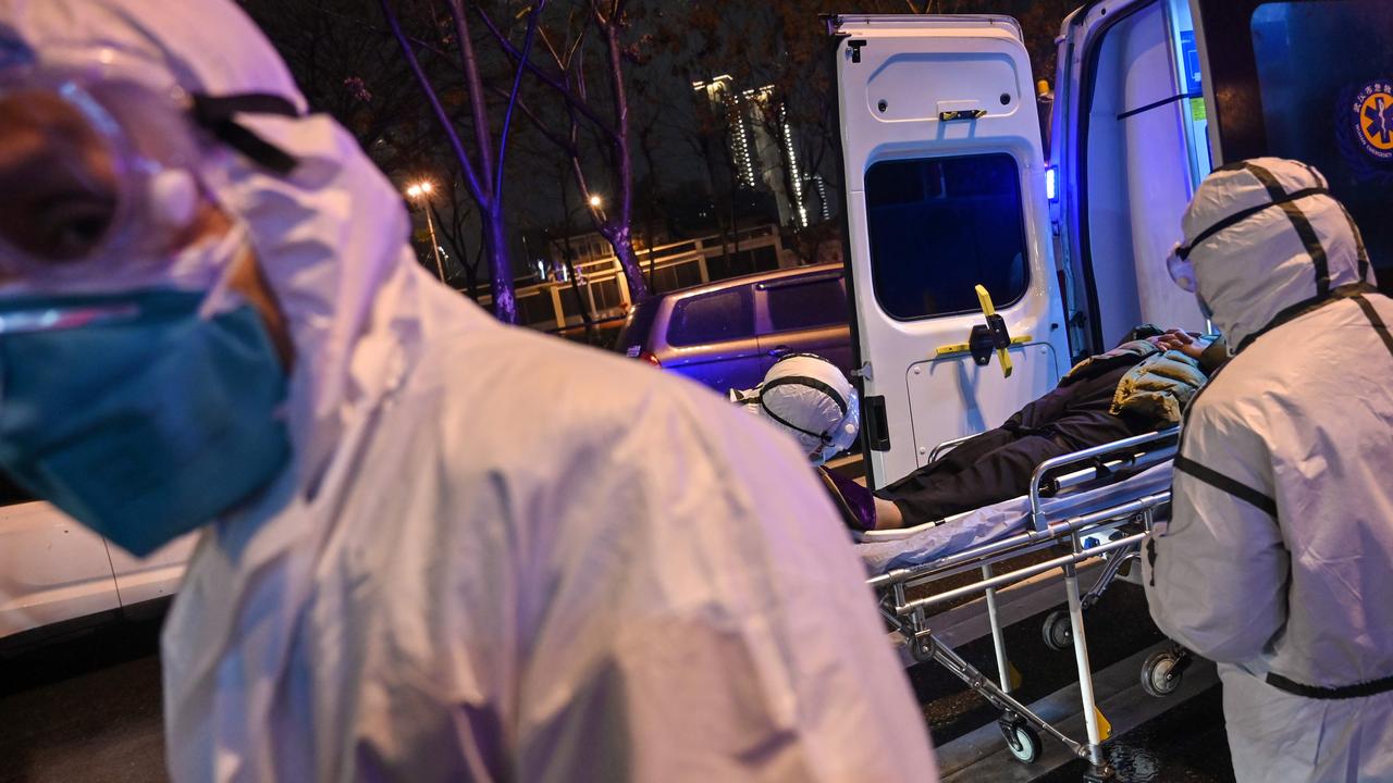 In this photo taken on January 25, 2020, medical staff wearing protective clothing to protect against a previously unknown coronavirus arrive with a patient at the Wuhan Red Cross Hospital in Wuhan. Picture: Hector Retamal / AFP