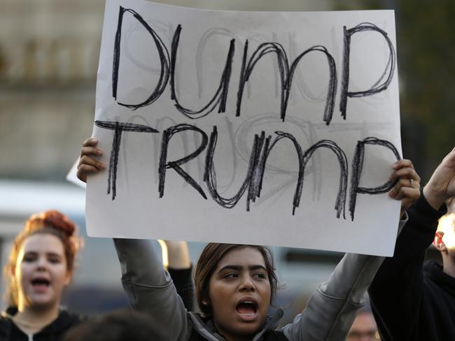 A protester holds a sign that reads ‘Dump Trump’ as she takes part in a protest against the election of Trump in downtown Seattle. Picture: Ted S. Warren/AP