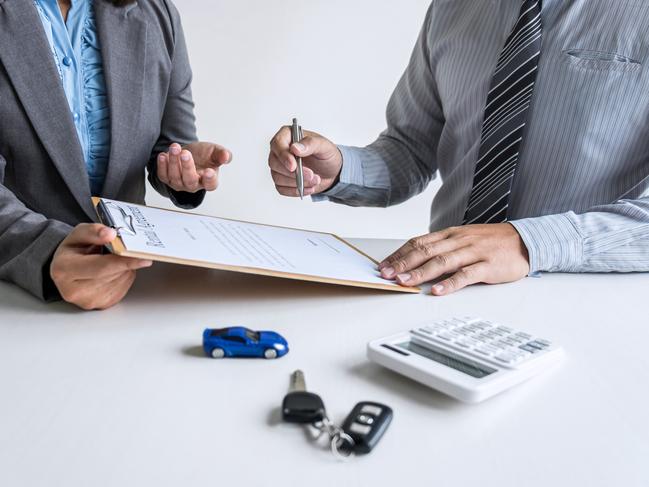 Realtor agent manager holding rental contract form to businessman client for decide signing to agreement, renting considering vehicle car insurance.  Tenant generic istock