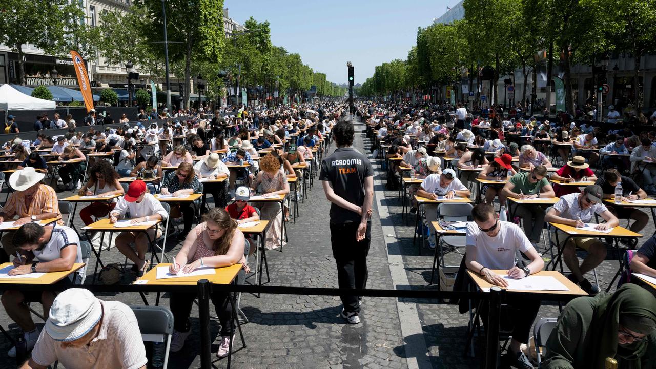 Participants attempt to beat the record for the world's biggest dictation on the prestigious Champs-Elysees Ave, transformed into a giant classroom, in Paris on June 4. Picture: Alain Jocard/AFP