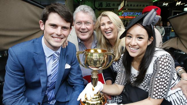 2015 Melbourne Cup Parade. Family of the late Bart Cummings grandson James Cummings with wife Monica and son Anthony Cummings with wife Bernadette travel the route in a horse drawn carriage with Light Fingerâ€™s 1965 Melbourne Cup trophy. Picture: David Caird.