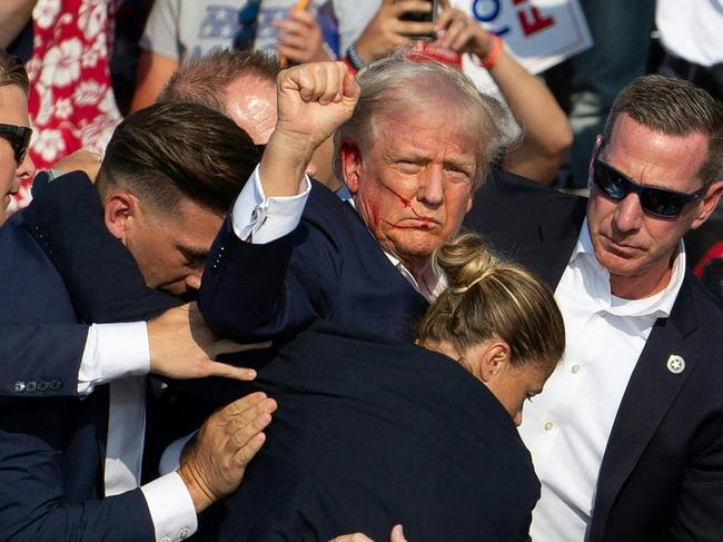 Donald Trump surrounded by secret service agents as he is taken off the stage after being shot at a campaign event in Pennsylvania on July 13, 2024. Picture: AFP