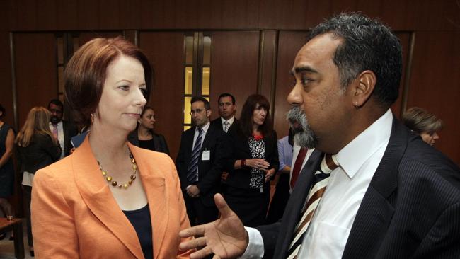 Then prime minister Julia Gillard talks with Romlie Mokak, who headed the Australian Indigenous Doctors Association, before delivering her statement on Closing The Gap in the House of Representatives in 2012. Picture: Ray Strange
