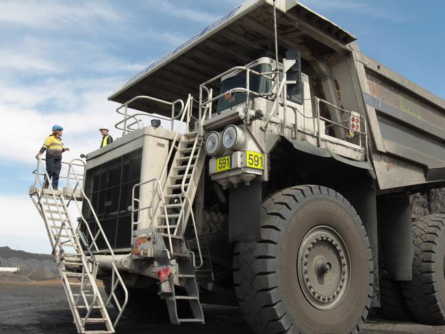 Worker Peta Jane (PJ) Fee took The Advertiser on a tour of the Leigh Creek coal mine, which is now operated by Alinta and supplies coal to the Flinders Power Station also operated by Alinta. Worker Peta-Jane (PJ) Fee media liason for Alinta (l) and journalist Cameron England, looking over one of the giant ore trucks.