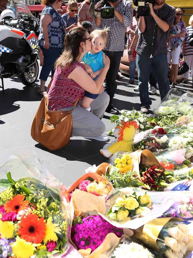 Visitors lay flowers at a shrine on Bourke St. Picture: Yuri Kouzmin