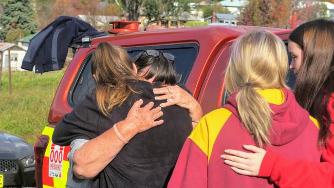 The girls’ grandmother, Sharon Dubois (obscured in grey shirt), visited the site to lay some flowers after the blaze. Picture: Toby Vue,