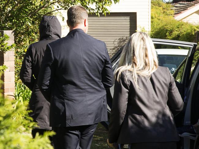 Friends and family are led into the house by detectives on Saturday. Picture: Jenny Evans