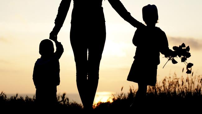 mother with her children at the seaside at sunset
