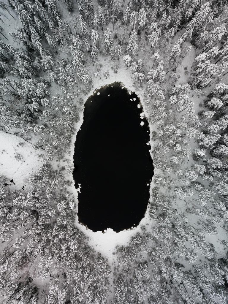 Image Name: Black hole Photographer Name: Damon Beckford Year: 2018 Image Description: A small pond and snow covered trees in Nuuksio National park, Finland. When the first snow came to Southern Finland, I headed to a national park near where I live and took my drone with me so I could capture some unique perspectives. Shot in November 2017. Copyright: Damon Beckford, Winner, Finland National Award. Picture: Sony World Photography Awards/ Damon Beckford