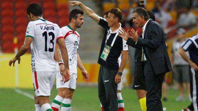 Carlos Queiroz (R), coach of Iran, speaks to player Soroush Rafiei (2nd L) during their Group C football match against the United Arab Emirates at the AFC Asian Cup in Brisbane on January 19, 2015. AFP PHOTO / John PRYKE --- IMAGE RESTRICTED TO EDITORIAL USE - STRICTLY NO COMMERICAL USE --