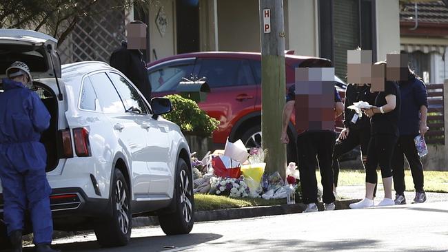 Family members and detectives visiting the floral tributes. Picture: Richard Dobson